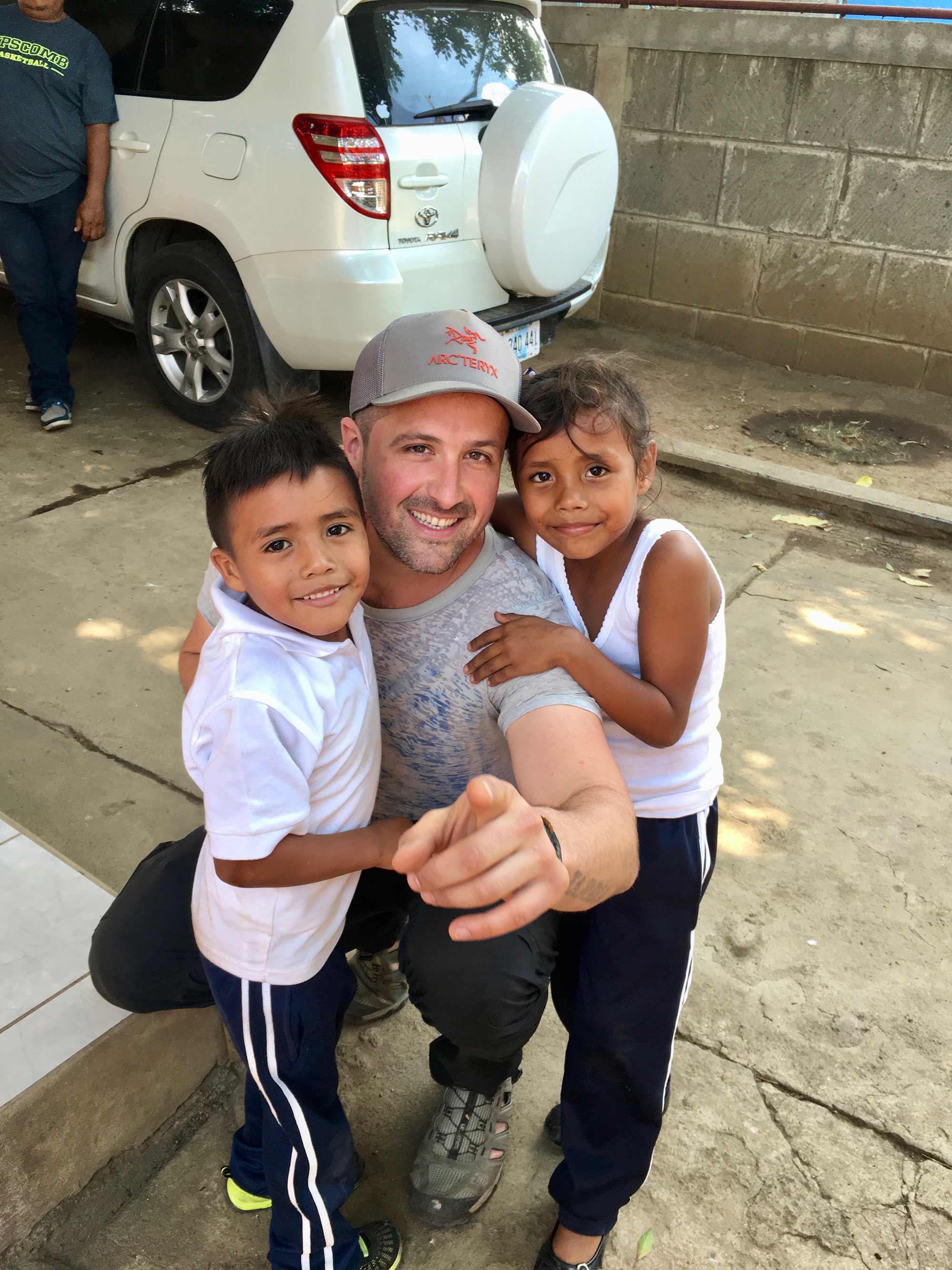 A Beauti of Hope volunteer with two children on the ground
